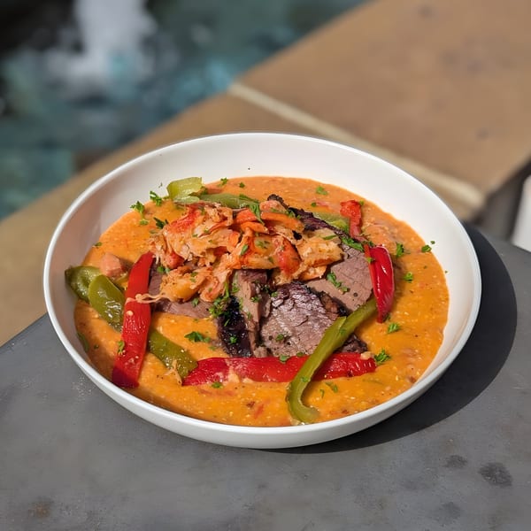 Doolittle's American dish with brisket, lobster, peppers, and a creamy orange sauce in a white bowl.